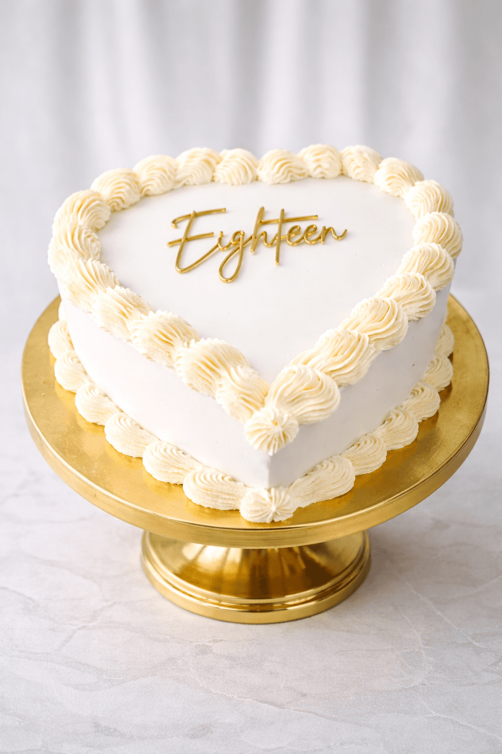 White heart-shaped cake with Eighteen gold topper