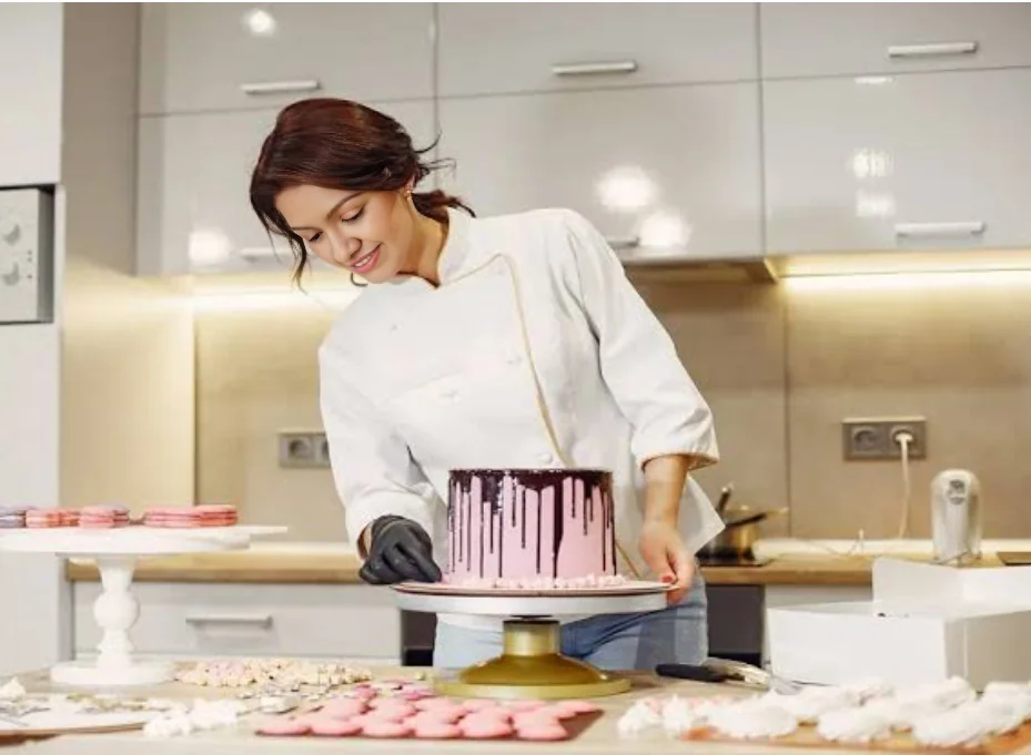 Udeni decorating a cake in her kitchen